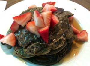 Buckwheat peanut butter pancakes topped with organic strawberries and real maple syrup